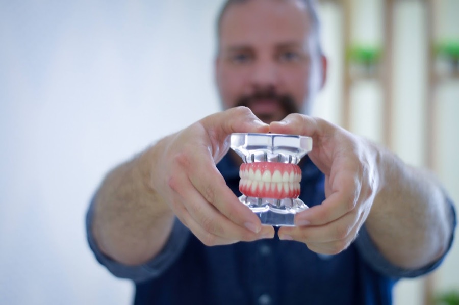Dentista da Sorrifácil segurando um modelo de prótese protocolo
